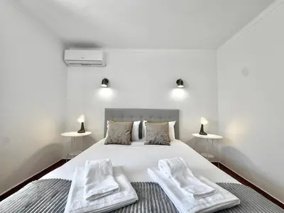a bedroom with a bed with two white towels on it at Beach 15 min away! - Rustic with AC and WiFi in Quarteira