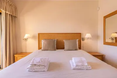 a bedroom with a bed with two towels on it at Vilamoura Residence in Quarteira