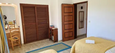 a bedroom with a bed and a wooden door at Sao Rafael Village 2 Bedroom with a Pool in Albufeira
