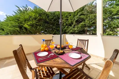 a dining table with an umbrella on a patio at Villa Colina - A1 by HelloVacations in Albufeira
