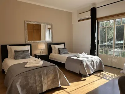 a bedroom with two beds and a window at Moradia B - 200m da Praia da Oura - Leste in Albufeira