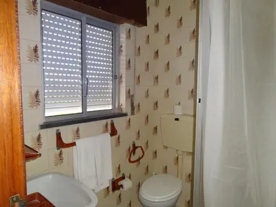 a bathroom with a white toilet and a window at Residencial Espadinha in Quarteira