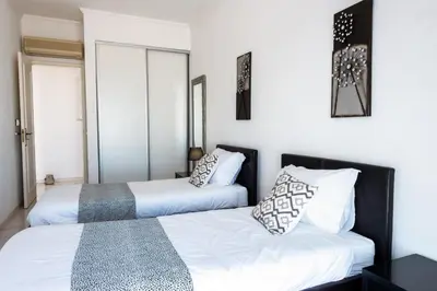 two beds in a room with white walls at Casa Sonhos in Albufeira