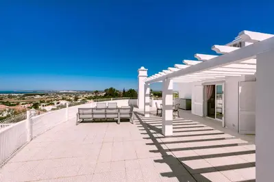 a patio with benches and a view of the ocean at Casa Sonhos in Albufeira