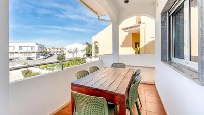 a balcony with a wooden table and chairs at Sunny 3BDR Apt with Pool in Ferreiras by LovelyStay in Albufeira