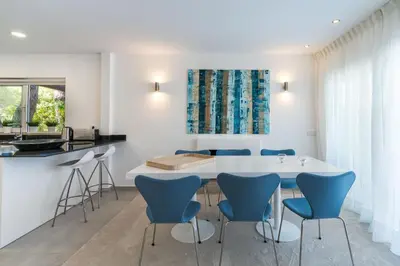 a kitchen with a white table and blue chairs at Villa Celeste by SAPvillas in Vilamoura