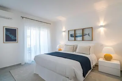a white bedroom with a large bed and a window at Villa Celeste by SAPvillas in Vilamoura