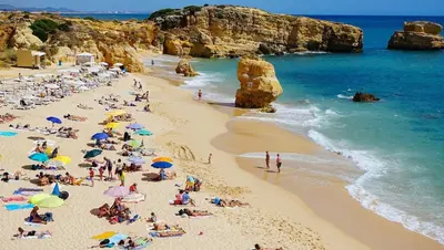 a group of people on a beach with umbrellas at Brand New Studio in Rua da Oura in Albufeira