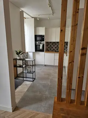 a kitchen with white cabinets and a tile floor at City Center Terrace in Faro