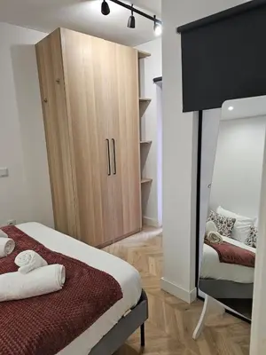 a bedroom with a bed and a cabinet and a mirror at City Center Terrace in Faro