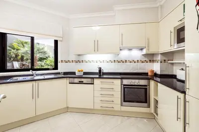 a white kitchen with white cabinets and a window at Albufeira Vista Marina Apt - Old Town in Albufeira