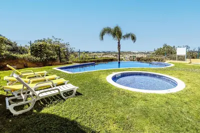 a group of lounge chairs next to a swimming pool at Albufeira Vista Marina Apt - Old Town in Albufeira