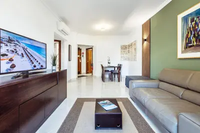 a living room with a couch and a flat screen tv at Albufeira Vista Marina Apt - Old Town in Albufeira