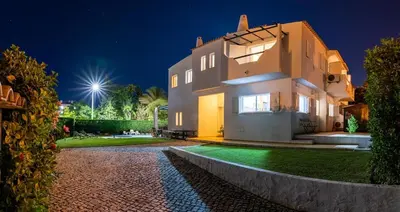 a large white house at night with a driveway at Vila Anna in Albufeira