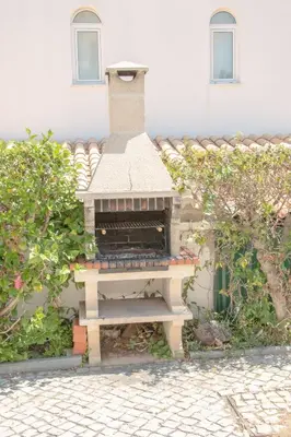 a brick oven sitting in front of a building at Vila Anna in Albufeira