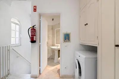 a white laundry room with a washer and dryer at Villa Rebelo in Albufeira