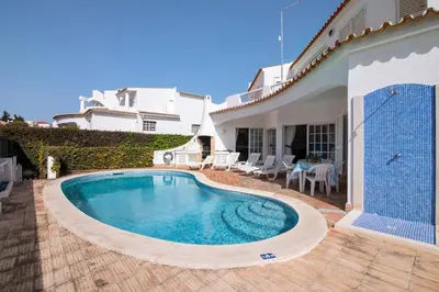 a swimming pool in the backyard of a house at Villa Rebelo in Albufeira