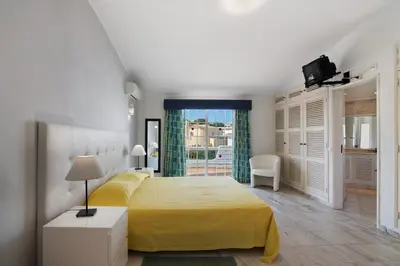 a bedroom with a yellow bed and a window at Villa Rebelo in Albufeira