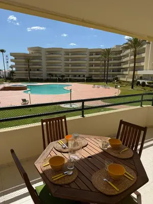 a wooden table with chairs and a view of a pool at Galé Mar By Albufeira Rental in Albufeira