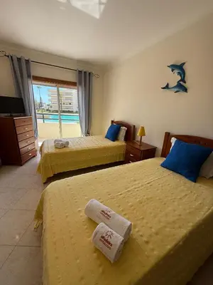a hotel room with two beds with towels on them at Galé Mar By Albufeira Rental in Albufeira