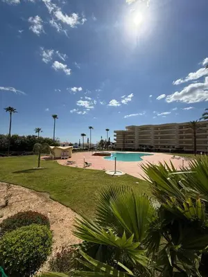 a swimming pool with palm trees and a building at Galé Mar By Albufeira Rental in Albufeira