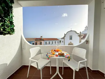 a table with a donut and glasses of orange juice at Albufeira Ocean View III by Homing in Albufeira