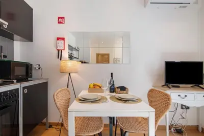 a small kitchen with a white table and chairs at Casa Viola in Faro