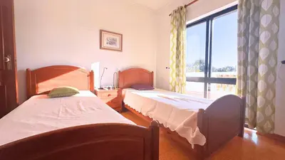 a bedroom with two beds and a large window at Casa das ficus in Guia