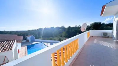 a balcony with yellow chairs and a swimming pool at Casa das ficus in Guia