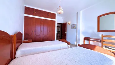a bedroom with two beds and a mirror at Casa das ficus in Guia