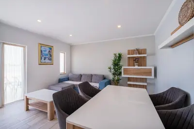 a living room with a couch and a table and chairs at Azinhais Apartment - Heart of Oura in Albufeira