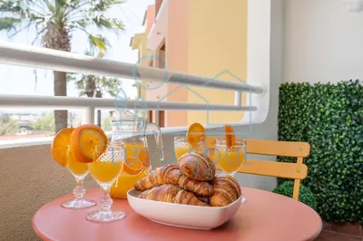 a table with a bowl of bread and glasses of orange juice at NEW! Perfect Studio with Swimming Pool in Albufeira