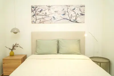 a bedroom with a bed with a painting on the wall at Stanchion Apartment in Albufeira