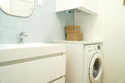 a bathroom with a washing machine and a sink at Stanchion Apartment in Albufeira