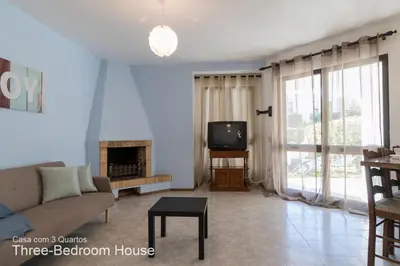 a living room with a couch and a tv at Akivillas Quarteira Relax in Quarteira