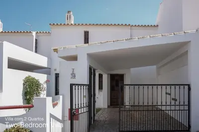 a white house with a gate in front of it at Akivillas Quarteira Relax in Quarteira