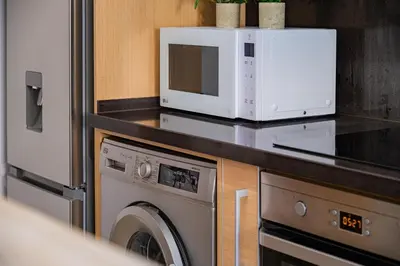 a microwave and a washing machine in a kitchen at Vale Parra Village By Cabritatur in Guia