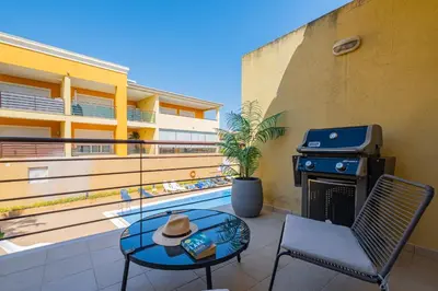 a patio with a grill and a table and chairs at Vale Parra Village By Cabritatur in Guia
