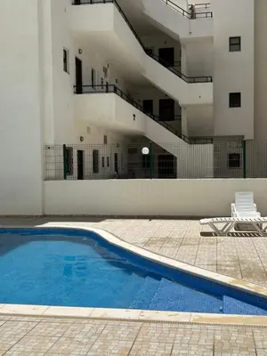 an empty swimming pool in front of a building at Quarteira Beach Home Haven in Quarteira