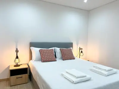 a bedroom with a bed with towels on it at Modern Retreat 700m from the Beach - Salgados in Guia