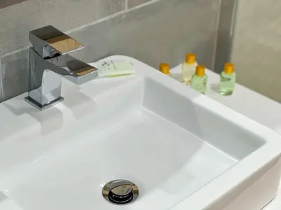 a white sink with a faucet and some bottles at Modern Retreat 700m from the Beach - Salgados in Guia