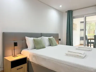 a bedroom with a large white bed with a window at Modern Retreat 700m from the Beach - Salgados in Guia