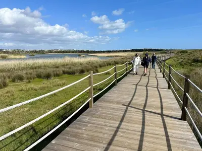 a group of people walking on a wooden boardwalk at Modern Retreat 700m from the Beach - Salgados in Guia