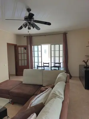 a living room with a couch and a ceiling fan at Casa Gomez A in Albufeira