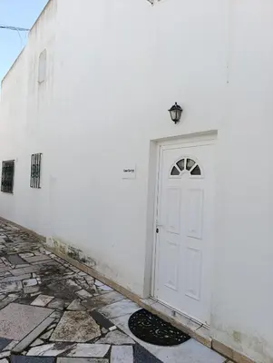 a white wall with a white door and a lamp at Casa Gomez A in Albufeira