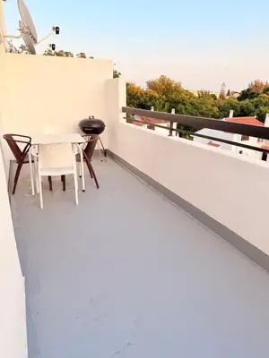 a balcony with a table and chairs on a building at OuraFlats in Albufeira
