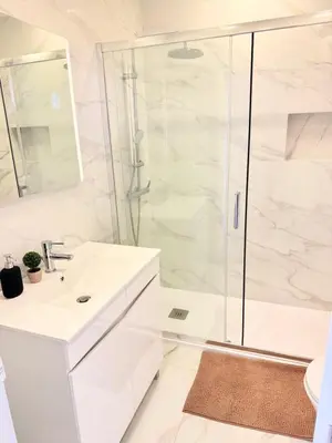 a white bathroom with a shower and a sink at OuraFlats in Albufeira