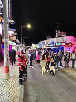a crowd of people walking down a street at night at OuraFlats in Albufeira