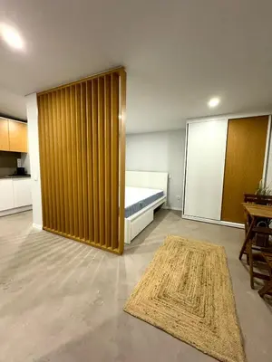 a bedroom with a bed and a wooden partition at Acoteias Cosy Studio in Albufeira