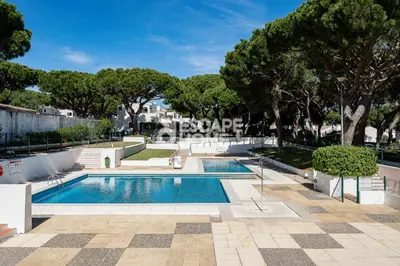 a swimming pool in a yard with trees at Acoteias Cosy Studio in Albufeira
